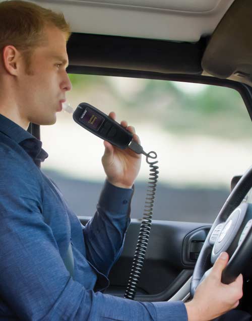 Young man blowing into his affordable interlock device